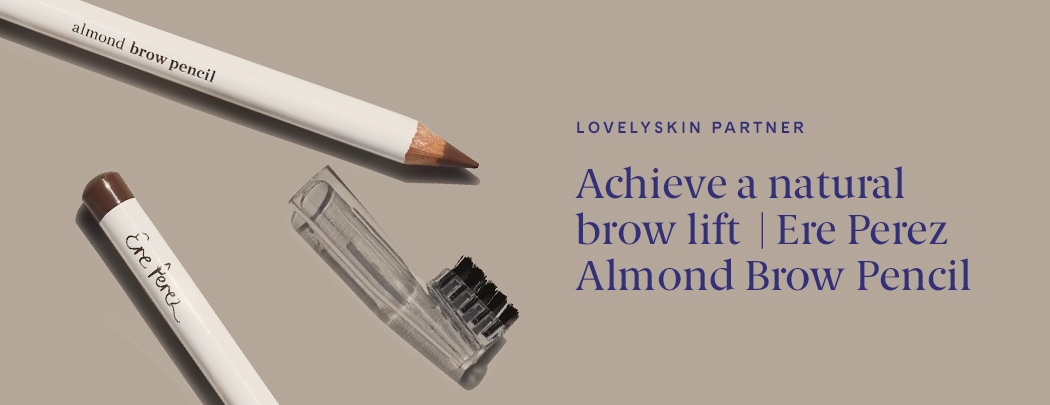 Two Ere Perez Almond Brow Pencils lay on a tan background with a lid and brush.