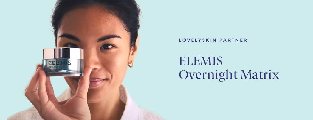 An asian woman smiling and holding a jar of ELEMIS Overnight Matrix over her face.