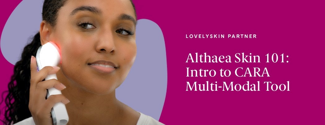 A woman with a deep skin tone and curled dark brown hair pulled into a low ponytail presses the Althaea Skin CARA Multi-Modal Tool to her face.