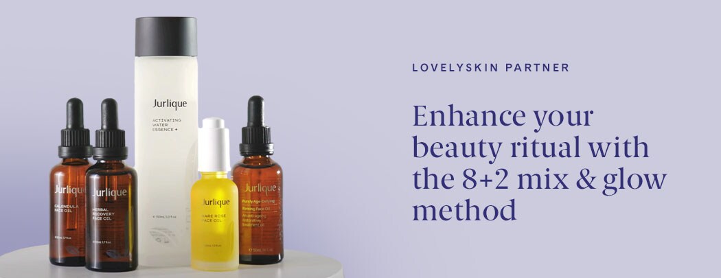 A clear bottle of clear liquid stands next to three brown bottles with black droppers and a gold bottle with a white dropper.