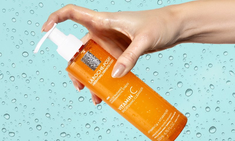 Hand holding cleanser bottle