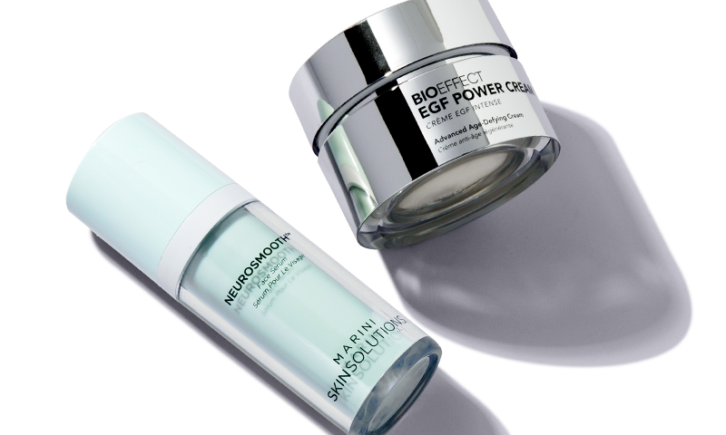 Two products containing growth factors, one in an airless pump jar and one in a traditional jar, lay next to one another.