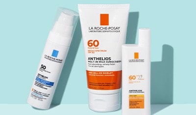 Three La Roche-Posay Anthelios sunscreen bottles on a light blue background.