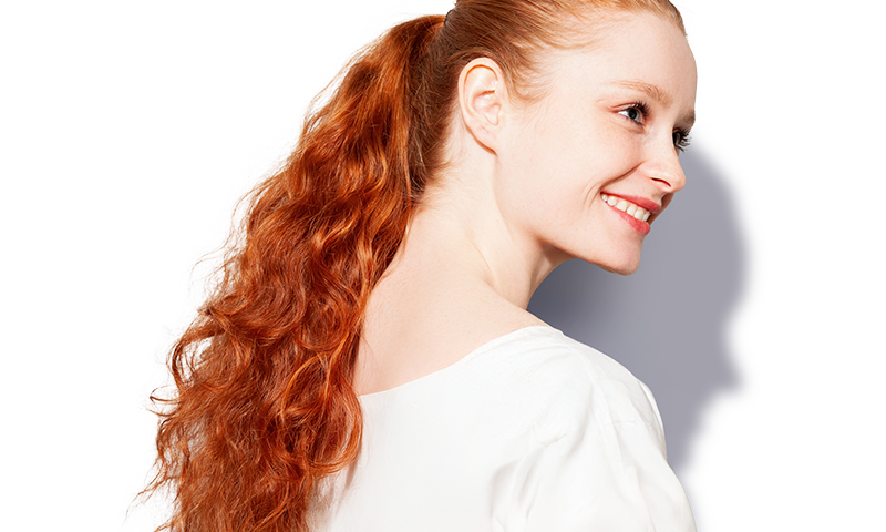 A woman with dyed red hair and a white shirt.