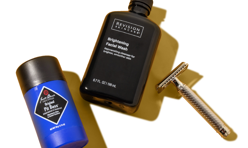 A razor and two men's products laying next to each other.