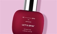 A red bottle of Joylux LET'S SPIN Intimacy Gel lays on a pink background.