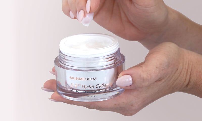 Hand swatching open SkinMedica HA5 Hydra Collagen Water Burst Moisturizer jar