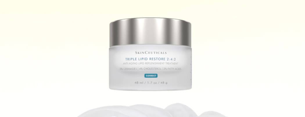 SkinCeuticals Triple Lipid Restore 2:4:2 Moisturizer floating above a table. Shop LovelySkin for SkinCeuticals top-rated skincare products. 