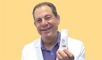 Image of Dr. Joel Schlesinger holding up a bottle of sunscreen