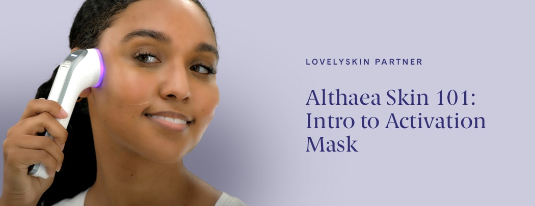 A woman with a deep skin tone and dark brown hair applies the Althaea Skin CARA Multi-Modal Tool to her face.