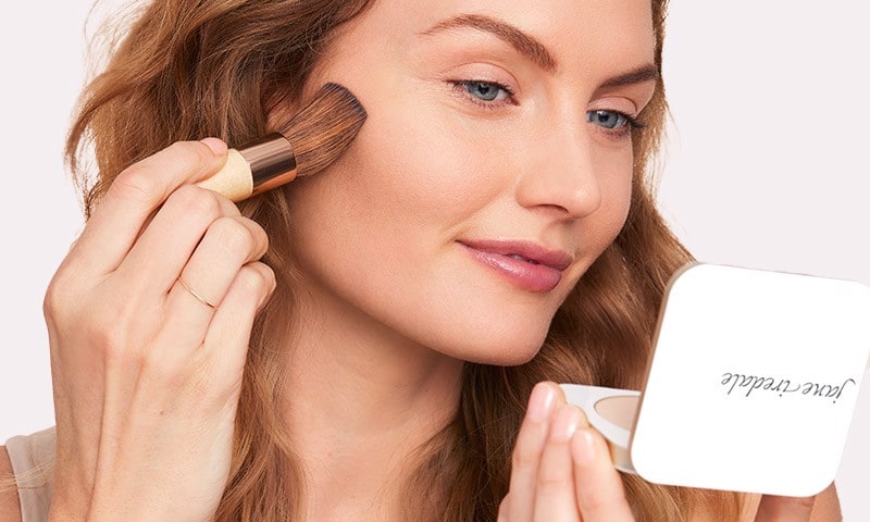 Woman applying foundation with makeup brush