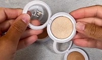 Two hands opening two compacts of powder highlighter