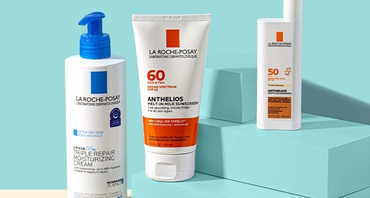 La Roche-Posay Anthelios sunscreens and Toleriane cleanser on a light blue background.