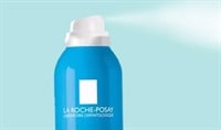 A blue bottle of La Roche-Posay Serozinc Zinc Sulfate Solution spraying.
