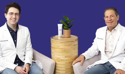 Two Drs in white jackets sit next to one another. There is a photo overlay of the Colorescience No-Show Mineral Body Sunscreen SPF 50.