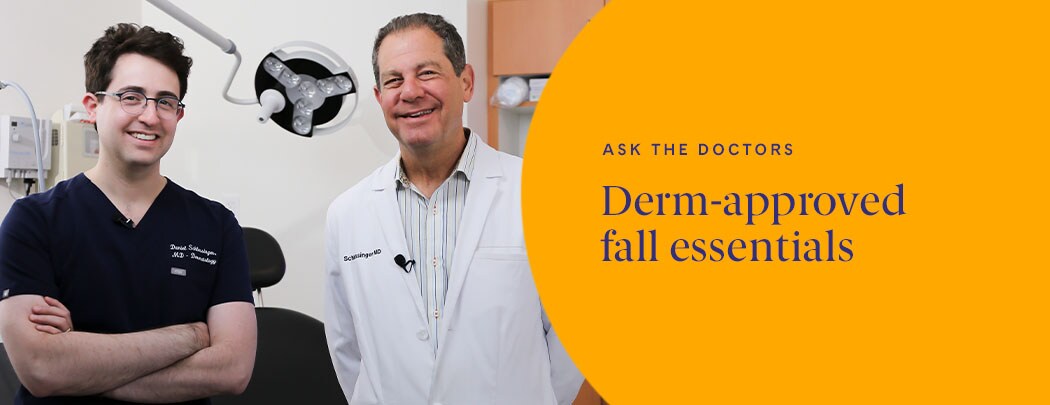 Two dermatologists, one with fair skin and dark hair smiles while crossing his arms next to one with light brown hair wearing a white jacket.