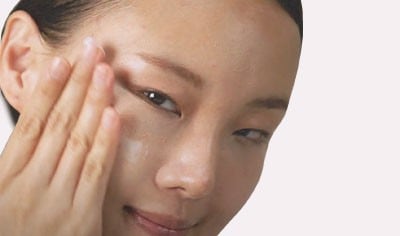 Young woman with her hand near her right eye