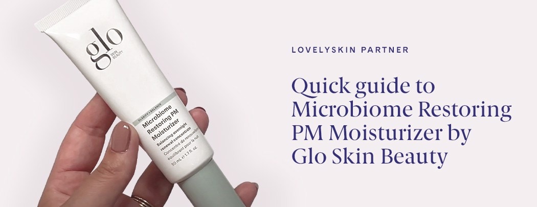 A hand with painted nails holding a tube of Glo Skin Beauty Microbiome Restoring PM Moisturizer