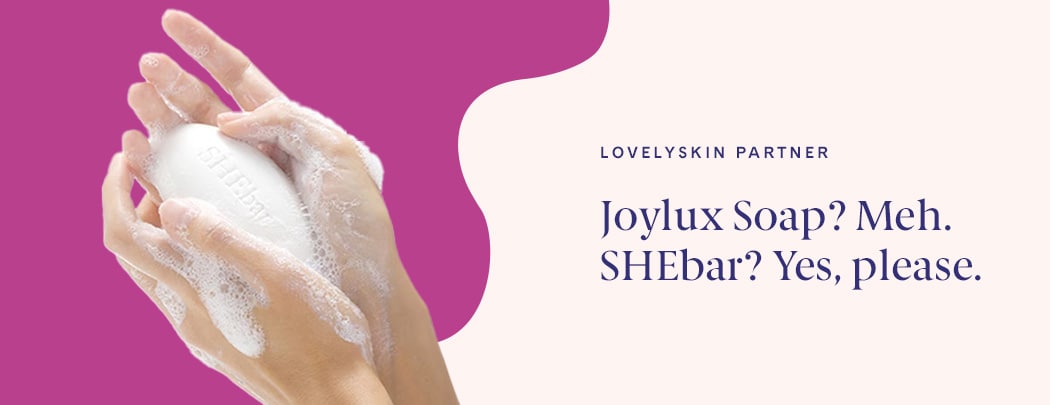 A person holds a bar of Joylux SHEbar® Intimate Soap in their hands. Their hands are sudsy and foamy.