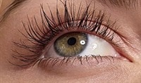 A person with olive-toned skin gazes upward. Their eye is a greenish hazel. Their eyelashes are long, lush and full.