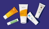 5 tubes of shea butter hand cream on a dark purple background.