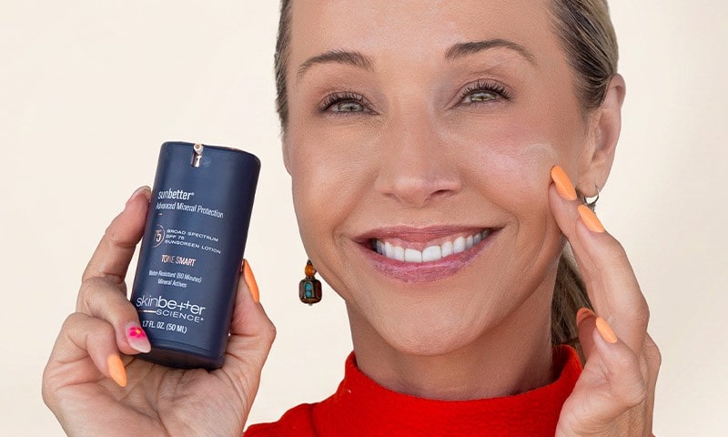 Woman applying sunscreen to her face