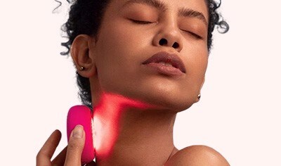 A woman holding the FOREO UFO 3 Deep Hydratration Facial device to her face