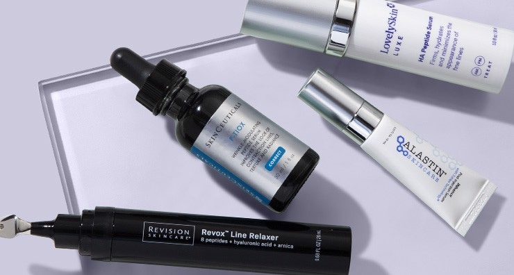 Anti-aging skin products from LovelySkin LUXE, SkinCeuticals, Alastin and Revision on a light purple background.