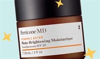 A jar of Perricone MD Vitamin C Ester Photo-Brightening Moisturizer Broad Spectrum SPF 30 with a blue background and sparkle illustrations.