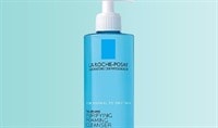 A blue bottle with a white pump of La Roche-Posay Toleriane Purifying Foaming Cleanser on a light blue background