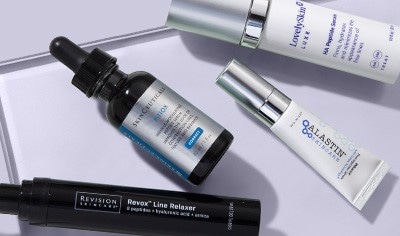 Anti-aging skin products from LovelySkin LUXE, SkinCeuticals, Alastin and Revision on a light purple background.