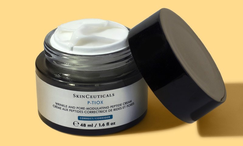 Open jar with rich white cream visible and the lid resting beside the container