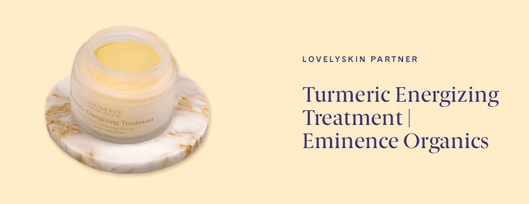 A glass pot of Eminence Organics Tumeric Energizing Treatment on a marbled tray